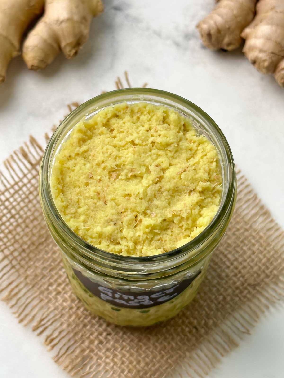 ginger paste in a glass jar with ginger knob on the side
