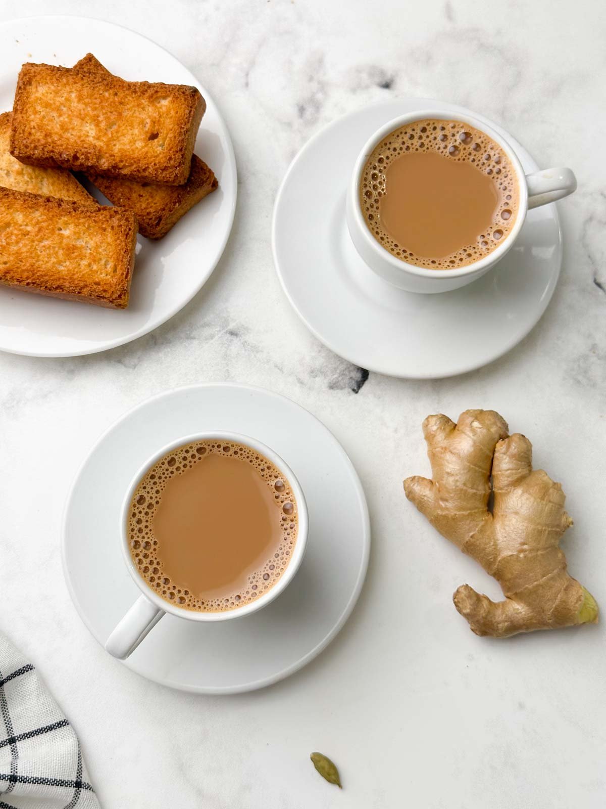 adrak wali chai served in a cup with rusk and ginger knob on the side