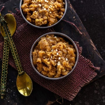 Besan Halwa served in two bowls with spoons on the side