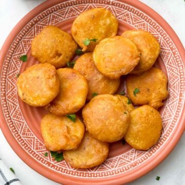 potato bajjis in a plate with tea and ketchup on the side