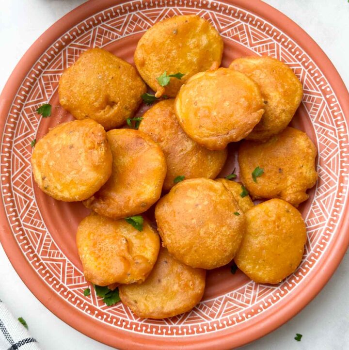 potato bajjis in a plate with tea and ketchup on the side