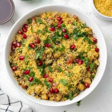 chana chaat served in a bowl and chutneys and sev on the side