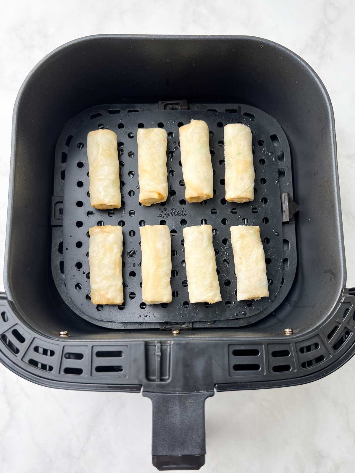 frozen spring rolls arranged for air frying