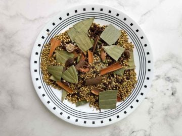 Dry roasted whole spices in a plate to cool.