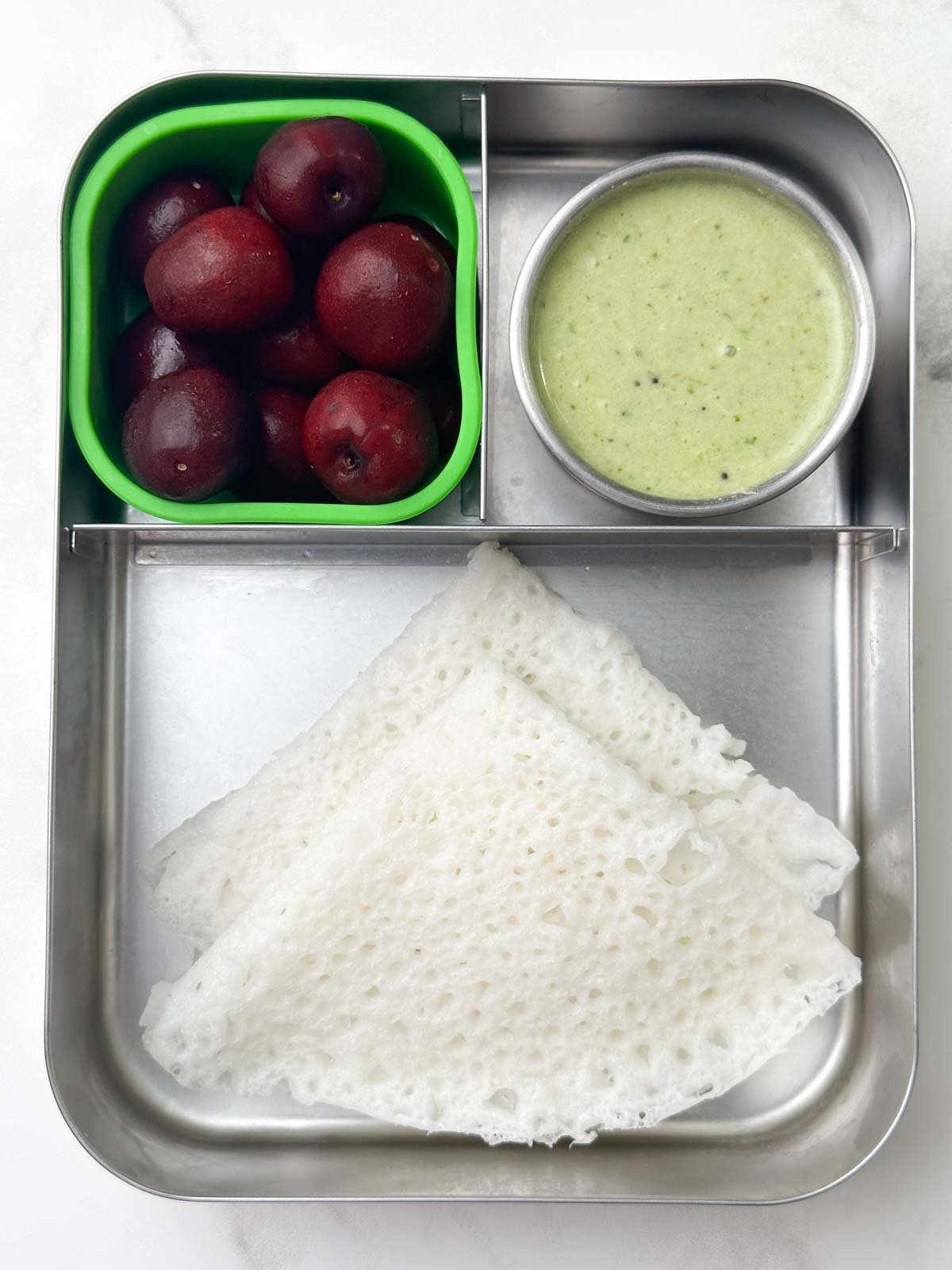 Neer Dosa with coriander coconut chutney, and red cherries.