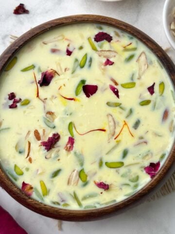 Paneer (Indian cottage cheese) kheer served in a wooden bowl with chopped almonds on the side