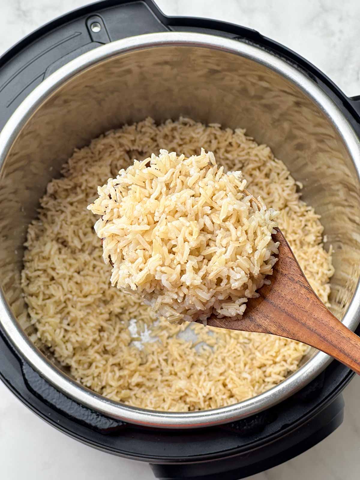 fluffy brown basmati rice in a ladle and instant opot