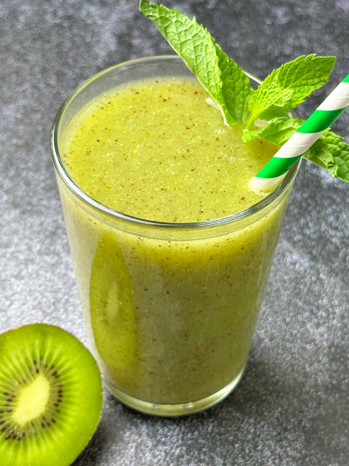 fruit juice served in a glass with mint on top