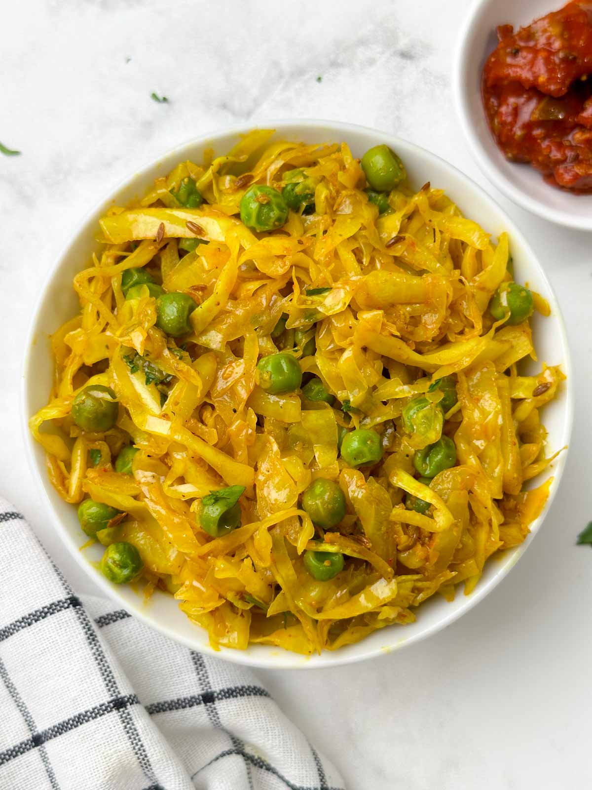 Indian cabbage peas sabzi (Patta Gobi Recipe) served in a bowl with pickle on the side