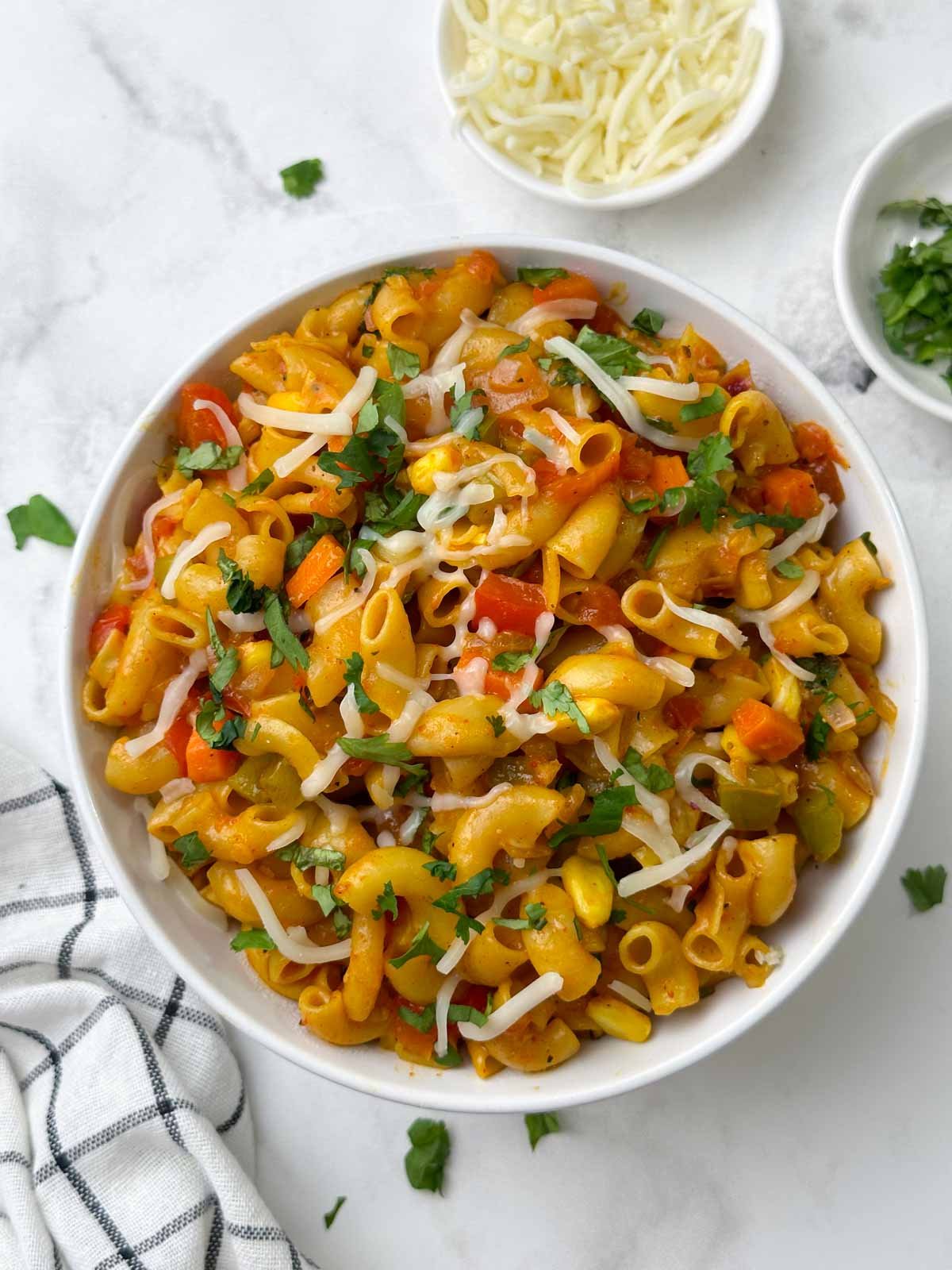 masala macaroni pasta served in a bowl with cheese on the side