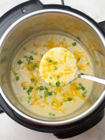 creamy loaded potato soup in the instant pot with a spoon ful off soup