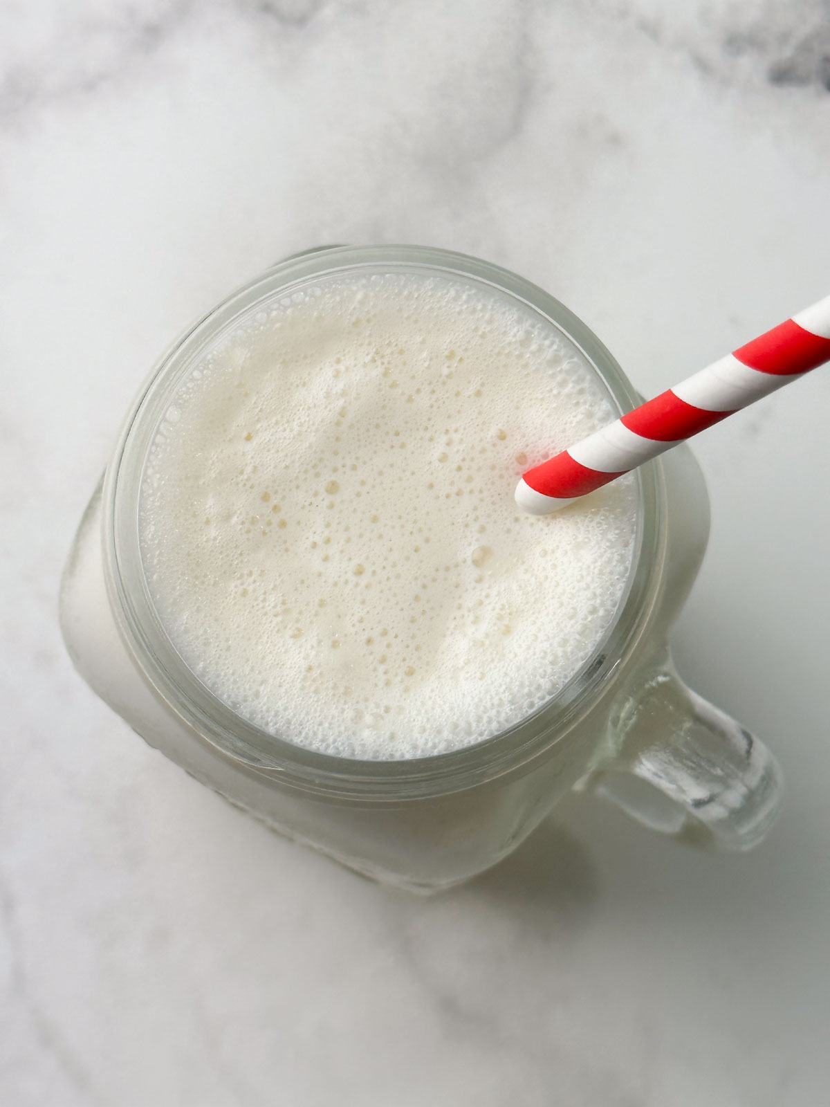 icecream shake in a mason jar with a straw