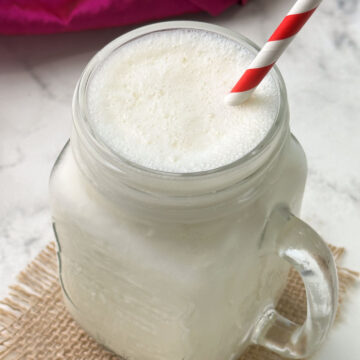 vanilla milkshake in a mason jar with a straw