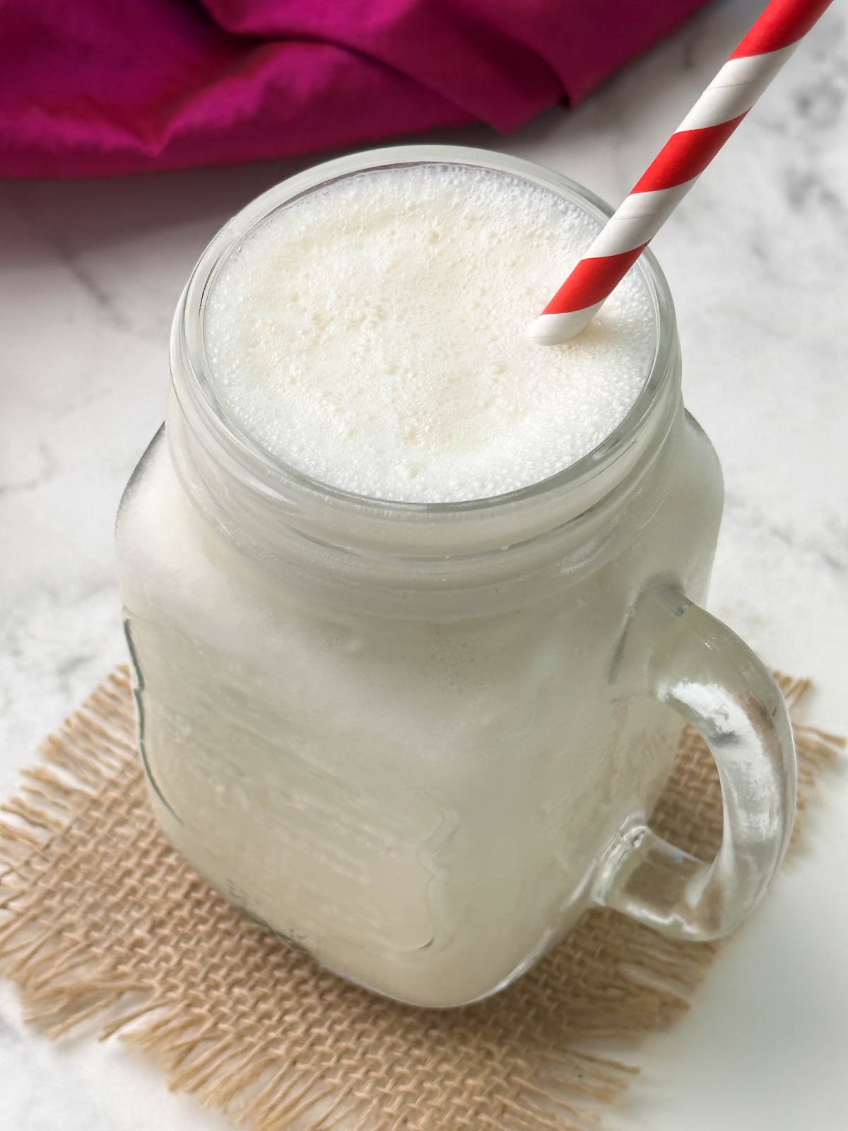 vanilla milkshake in a mason jar with a straw