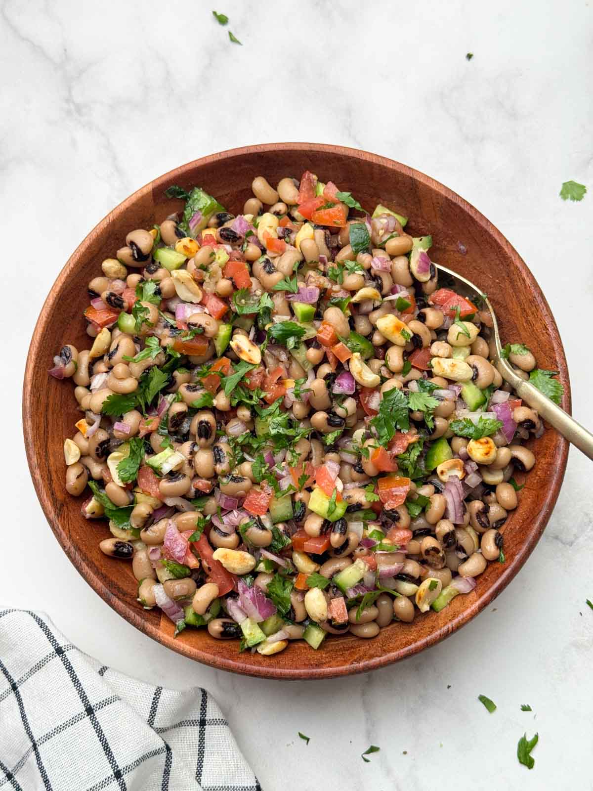 black eyed peas salad (lobia chaat) served in a wooden bowl with a spoon