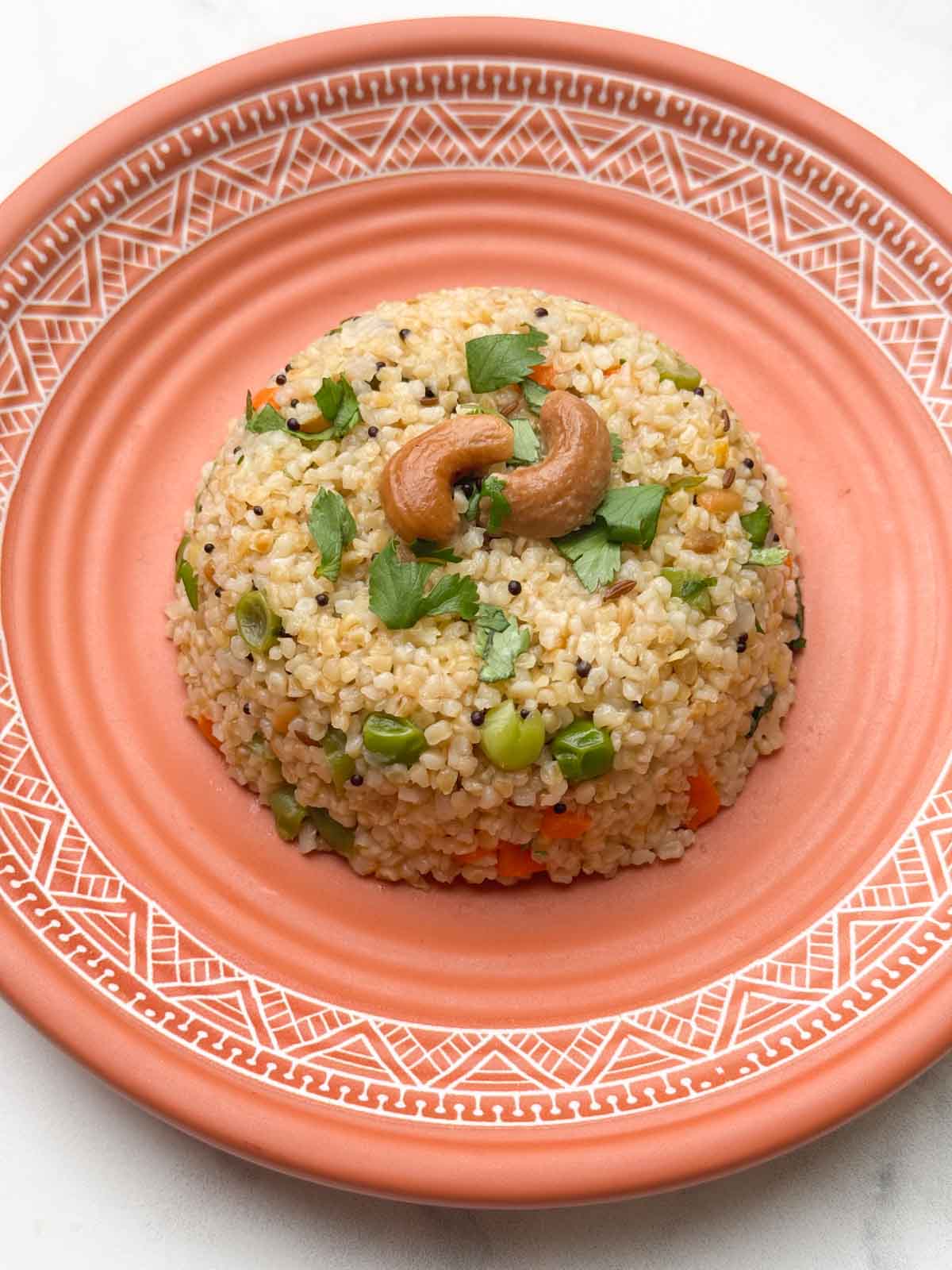 dalia upma (broken wheat upma) recipe served in a plate