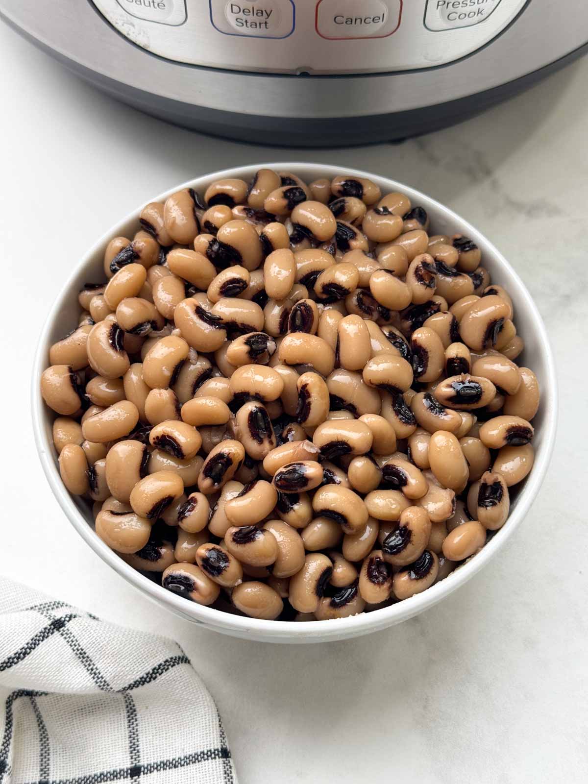 black eyed peas in a bowl with instant pot behind
