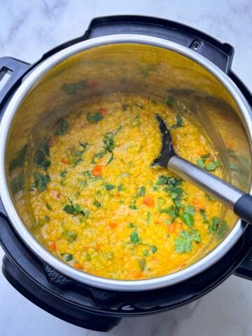 oats khichdi in the instant pot insert with a spoon