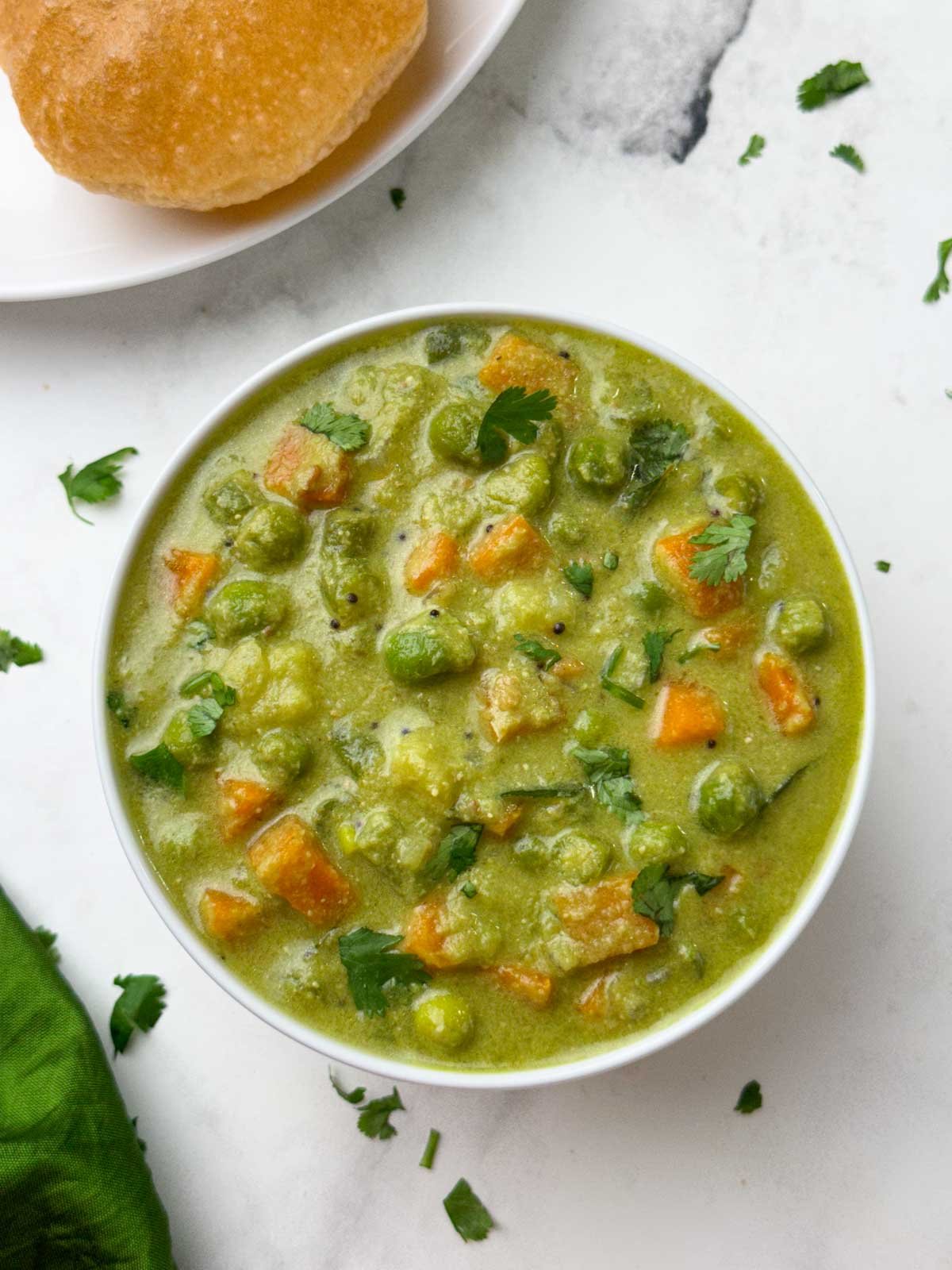 karnataka style vegetable sagu served in a bowl with poori on the side