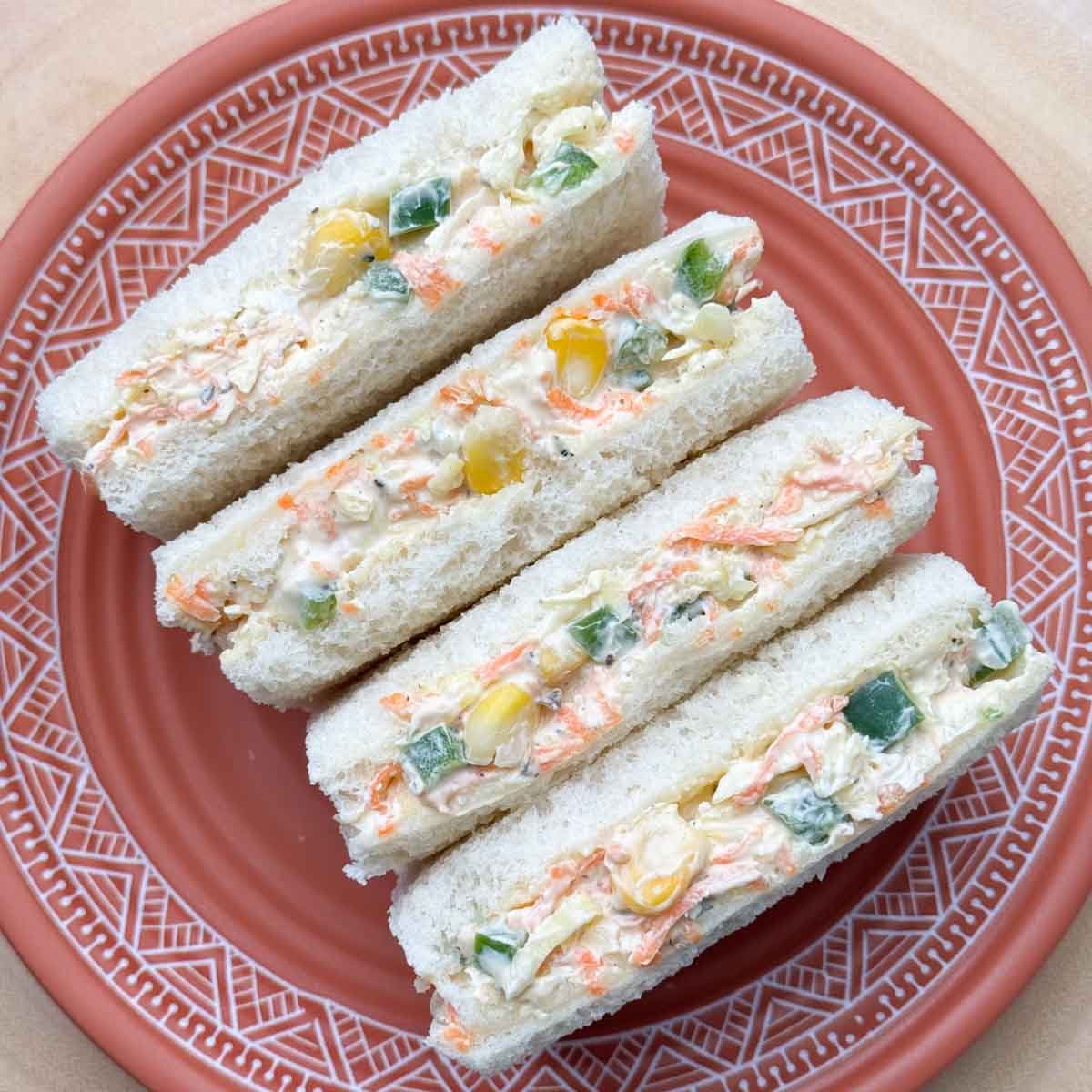 four slices of vegetable cream cheese sandwich in a plate