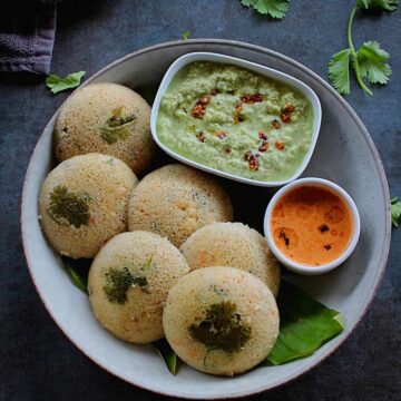 oats idli served on a plate with green and red coconut chutney