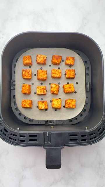 Paneer pieces in the air fryer basket