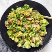 High protein soya chunks salad with greek yogurt dressing on a black bowl with a golden spoon on it.