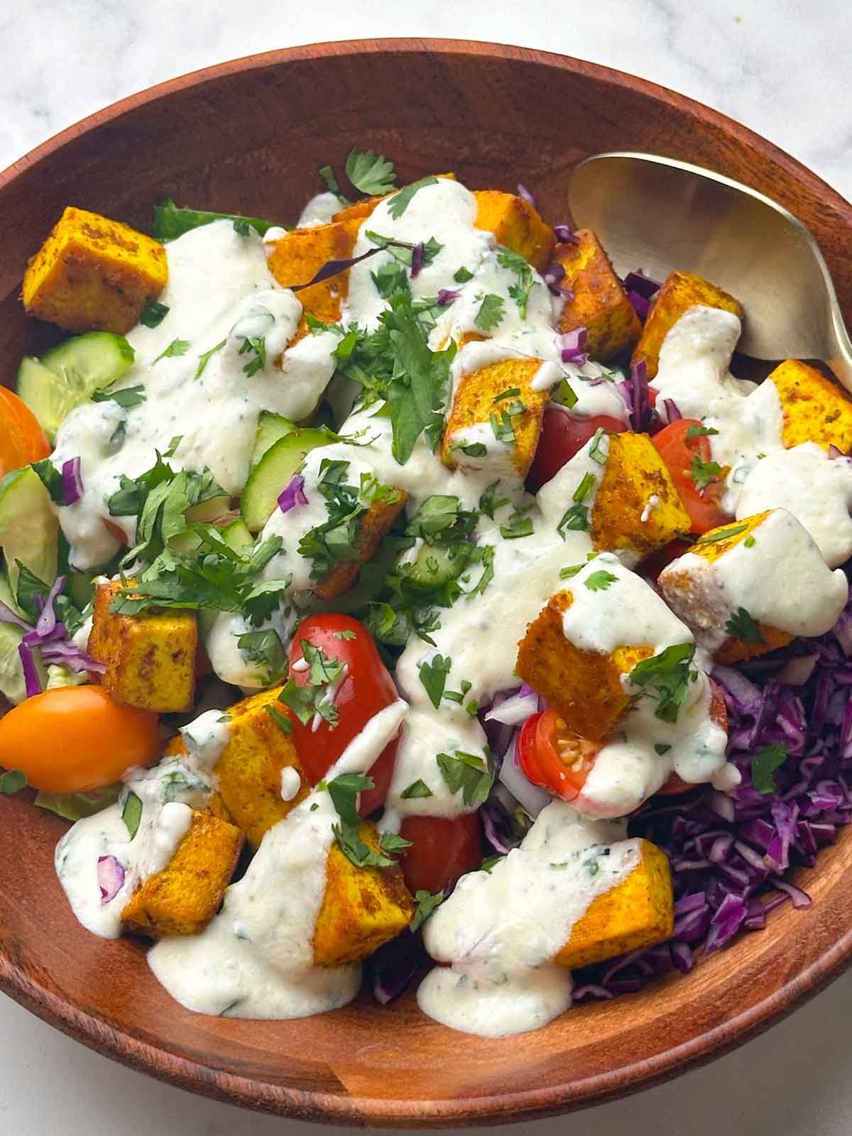 tofu salad indian style served in a bowl with a spoon on it.