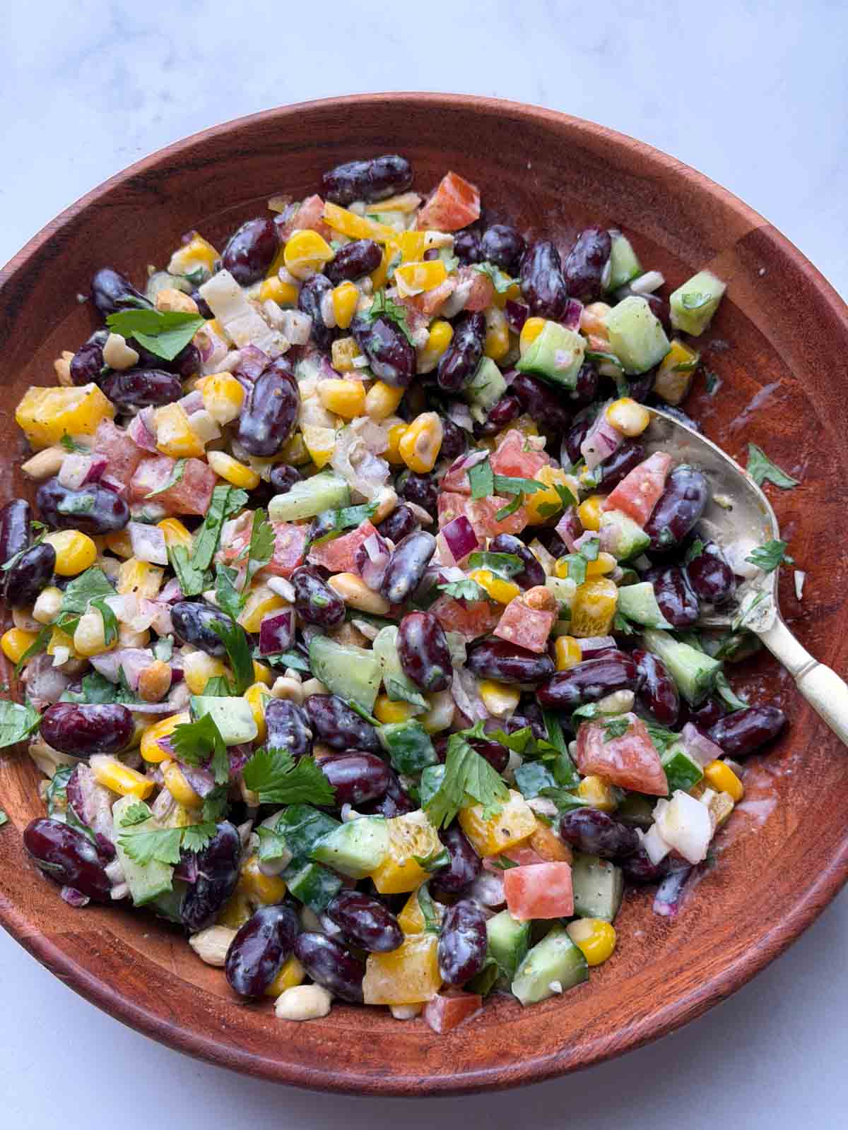 Indian rajma salad in a wooden bowl with a spoon on it.
