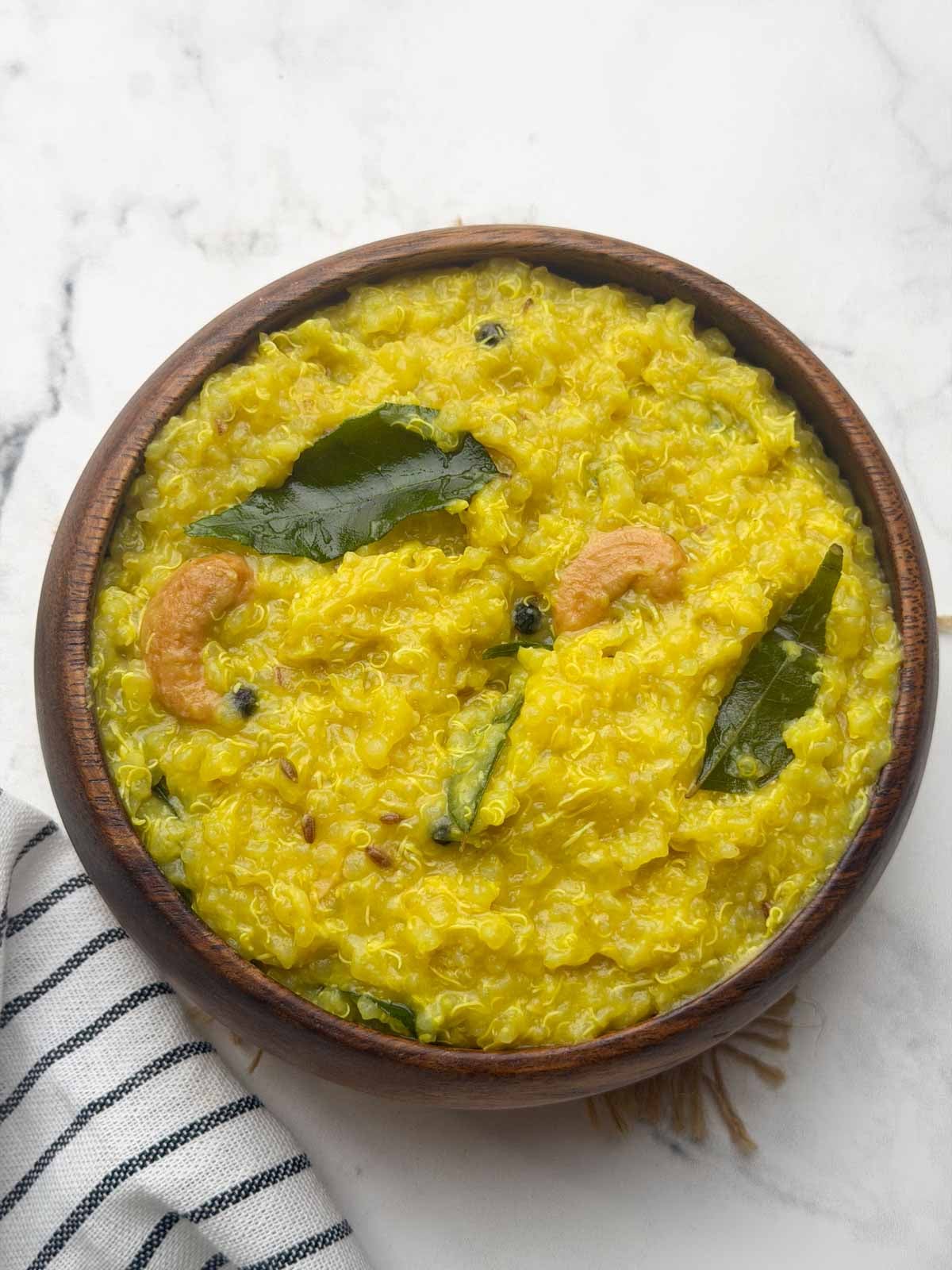 Quinoa pongal served in a brown bowl.