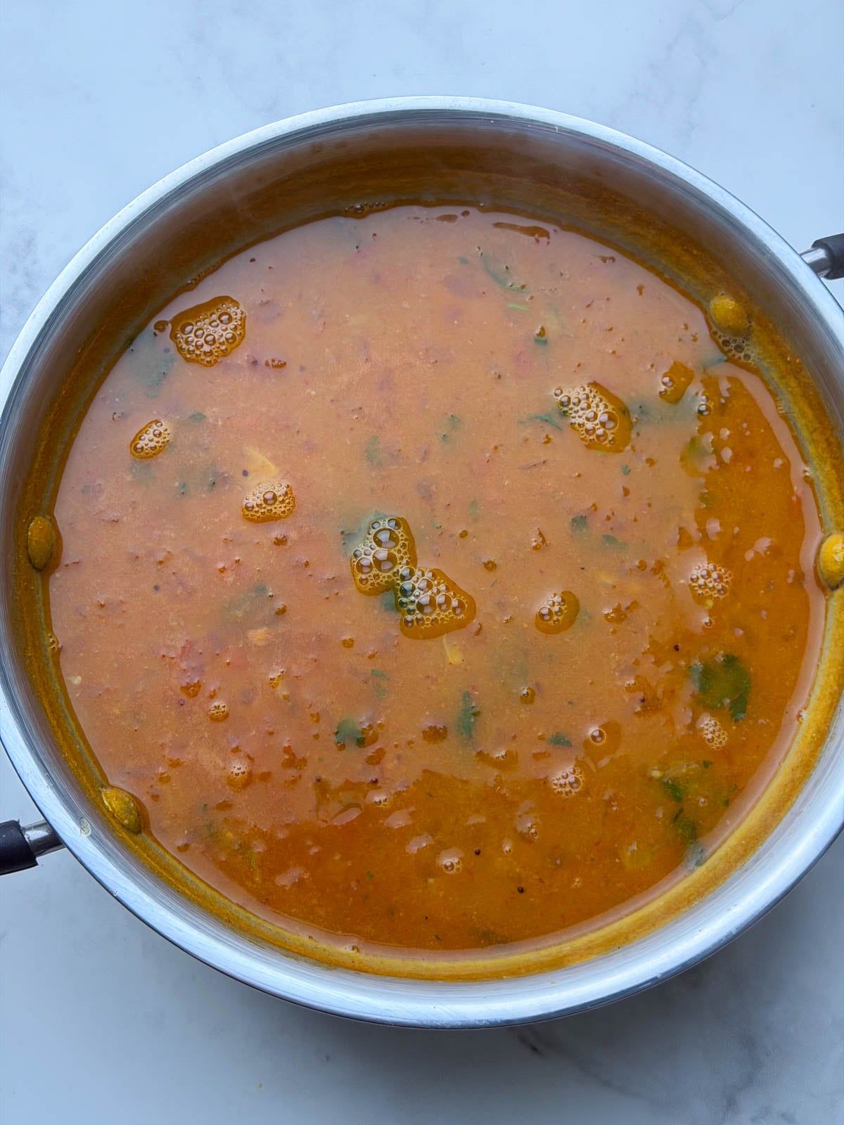 Tomato Coconut milk rasam in kadai.